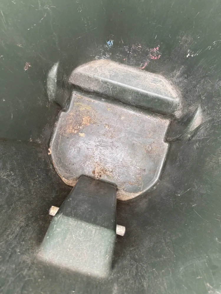 Grimy trash can bottom before pressure washing